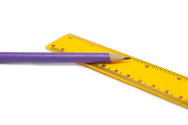 Фиолетовый карандаш и жёлтая линейка — стоковое фото