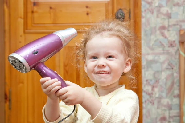 Menina pequena com secador de cabelo — Fotografia de Stock