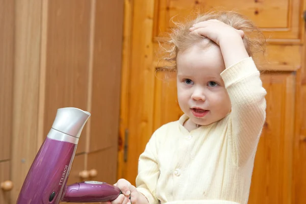 Menina pequena com secador de cabelo — Fotografia de Stock