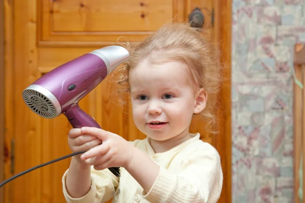 Menina pequena com secador de cabelo — Fotografia de Stock