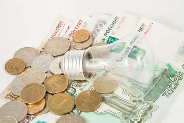 The bulb and is a lot of coins — Stock Photo, Image