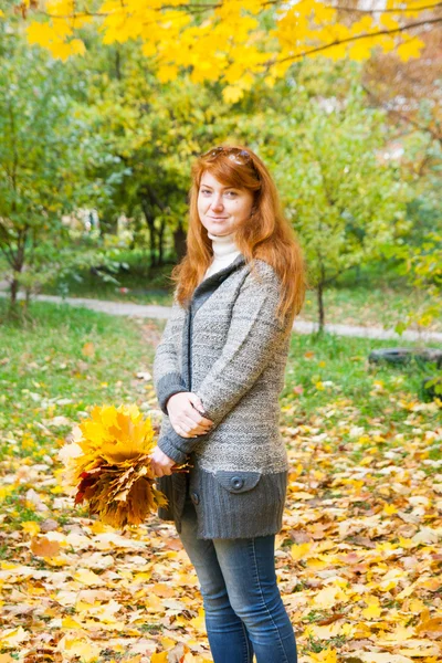 Rödhårig flicka på hösten utomhus Stockbild