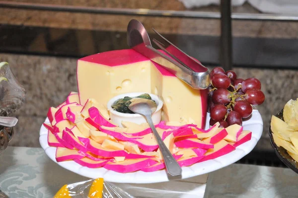 Beyaz gümüşün üzerinde lezzetli peynir ve yanında da üzüm.