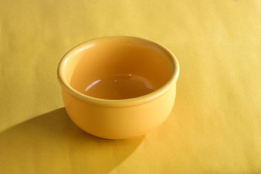 Sarı porselen kase, sarı arka planda boş.