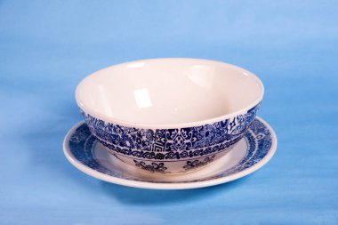 Açık mavi arkaplanda izole edilmiş saplı tasarımı olan beyaz renkli porselen bardak