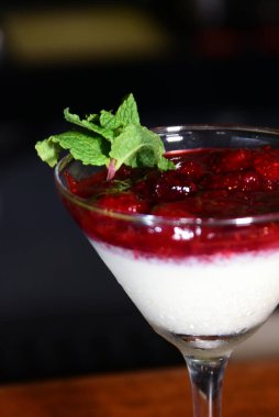 Kırmızı meyve, ahududu sosu, kremalı çilek ve cam kasede servis edilen reçel.