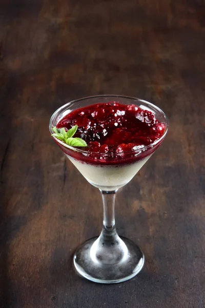 Kırmızı meyve, ahududu sosu, kremalı çilek ve cam kasede servis edilen reçel.