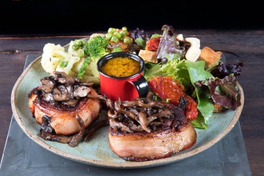 Domuz pastırmalı biftek, sebze salatası ve hardal soslu tabak.