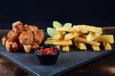 Kızarmış manyok ve limonlu domuz pastırması.