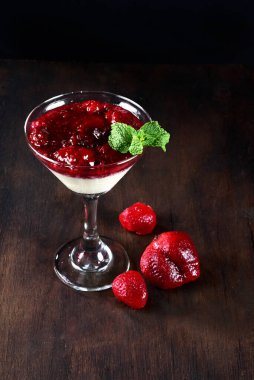 Kırmızı meyve, ahududu sosu, kremalı çilek ve cam kasede servis edilen reçel.