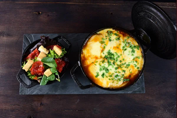 Sos ve peynirli lezzetli köfteler, kızarmış ekmek ve baharatlı yemekler, sebze salatası.