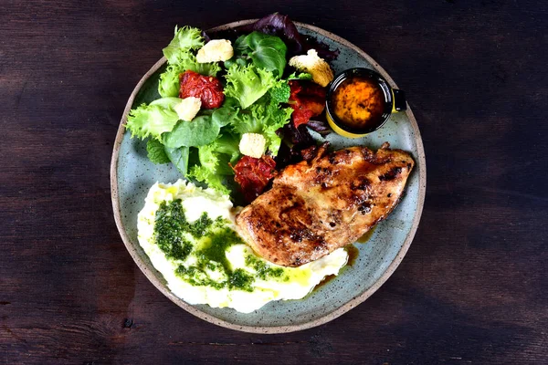 Kızarmış tavuklu bir tabak domuz pastırmalı sebze salatası ve hardal soslu.