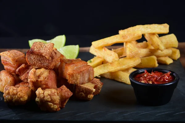 Kızarmış manyok ve limonlu domuz pastırması.