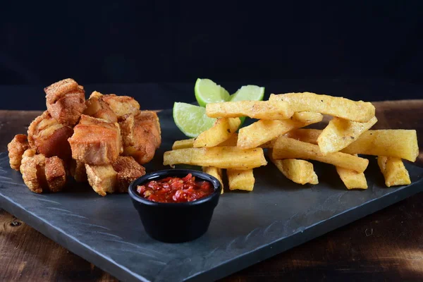 Kızarmış manyok ve limonlu domuz pastırması.