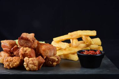 Kızarmış domuz derisi, kızarmış domuz pastırması, kızarmış manyok ve kırmızı sos, domuz göbeği.