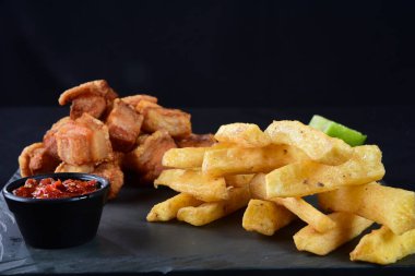 Kızarmış domuz derisi, kızarmış domuz pastırması, kızarmış manyok ve kırmızı sos, domuz göbeği.