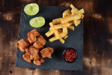 Kızarmış domuz derisi, kızarmış domuz pastırması, kızarmış manyok ve kırmızı sos, domuz göbeği.