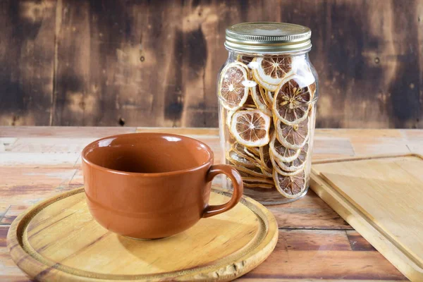 木製のテーブルの上の空の磁器カップ背景に脱水レモンと瓶 — ストック写真