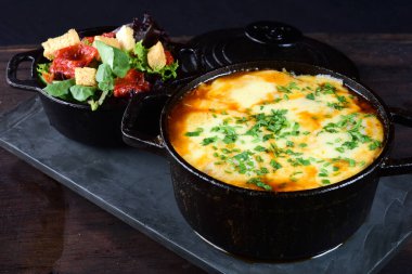 pan with meatballs rice cheese and salad, in iron pan on slate stone