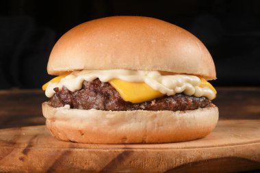 Lezzetli hamburgerli domates salatası ve siyah arka planda izole edilmiş ekmek.