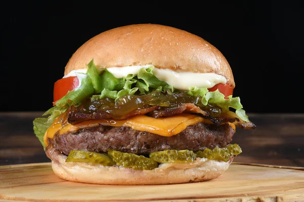 トマト玉ねぎのサラダと黒の背景に隔離されたパンのおいしいハンバーガーサンドイッチ — ストック写真