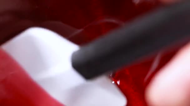 Close-up shot of a red glaze on a steel pan. Divide a caramel glaze with a white silicone spatula — Stock Video