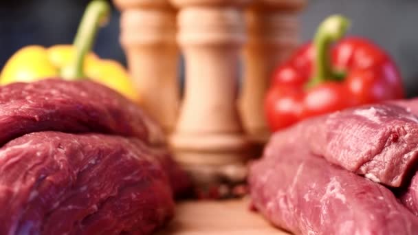 Extremt makro skott av bild mellan två rå nötkött filéer på träskiva med färgglada bakgrund — Stockvideo