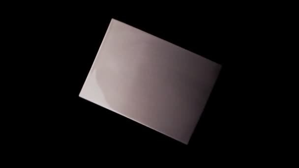 Izolovaná kovová deska s abstraktní texturou rotující na černém pozadí. Abstraktní reflexe na měděné desce — Stock video