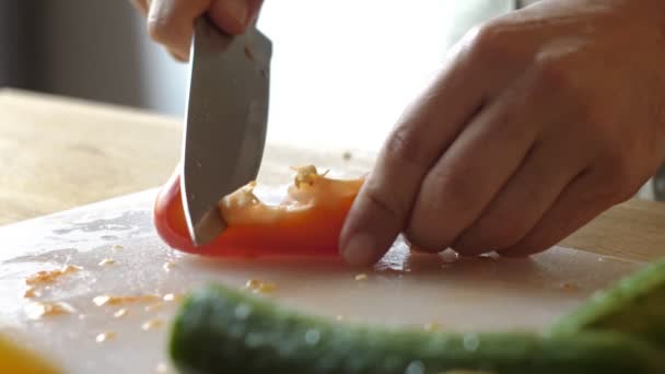 Un uomo che cucina cibo fresco a casa. Primo piano chef mani affettare pepe al rallentatore. Professionista maschile preparare verdure con coltello in cucina a casa — Video Stock