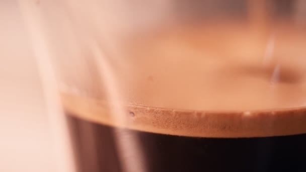 Közelről öntés kávé üvegpohárba fehér alapon — Stock videók