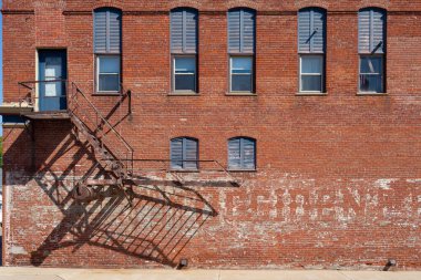 Paslı yangın çıkışlı eski tuğla binanın dışı..