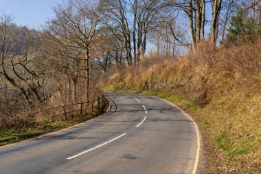 Güneşli bir bahar sabahı İngiliz kırsalında açık yol. Pooley Köprüsü, İngiltere.