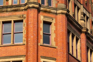 Güneşli bir bahar öğleden sonrasında, İngiliz şehrindeki eski tuğla binanın dışında..