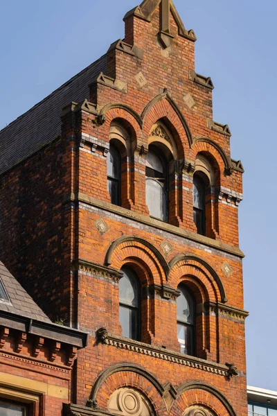 Güneşli bir bahar öğleden sonrasında, İngiliz şehrindeki eski tuğla binanın dışında..