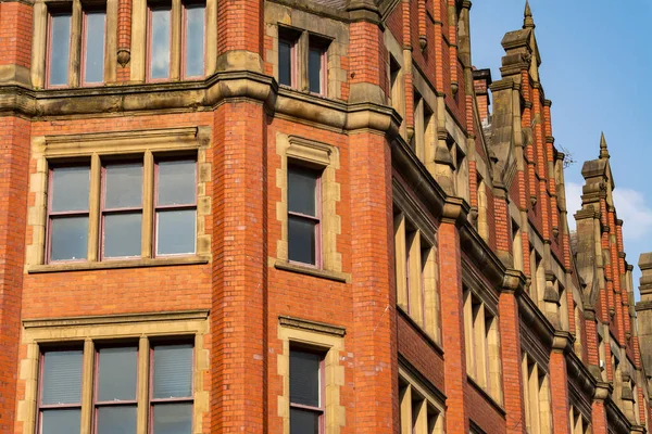 Güneşli bir bahar öğleden sonrasında, İngiliz şehrindeki eski tuğla binanın dışında..