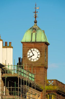 Güneşli bir bahar sabahı, İngiliz şehrinde eski güzel saat kulesi..
