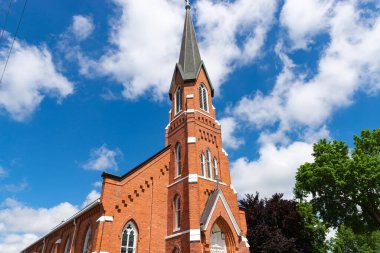 Küçük orta batı kasabasındaki güzel tuğla kilise. Arka planda mavi gökyüzü ve bulutlar var..