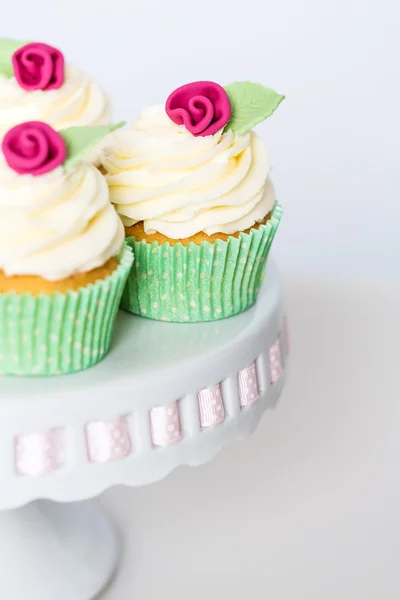 bir cakestand üzerinde çiçek cupcakes