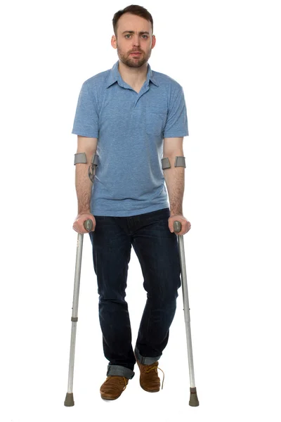 Jonge man lopen met onderarm krukken uitgeschakeld — Stockfoto