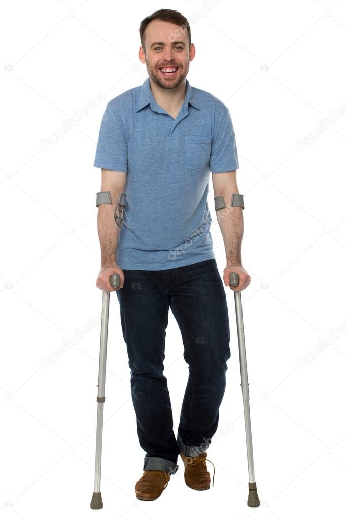 Smiling young man using crutches