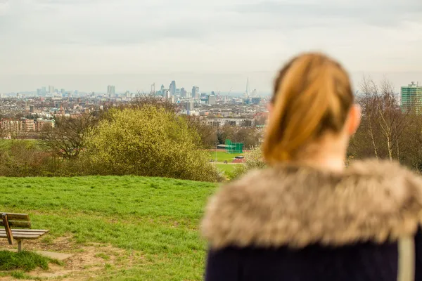 Woman looking out over countryside to a town — Stock Photo, Image