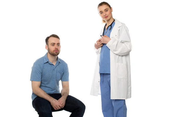 Paciente masculino sentado con médico femenino de pie — Foto de Stock