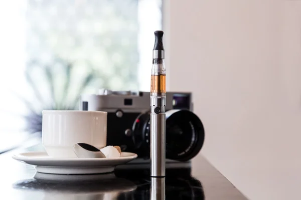 E-cigarett på en bar med kaffe och en kamera — Stockfoto