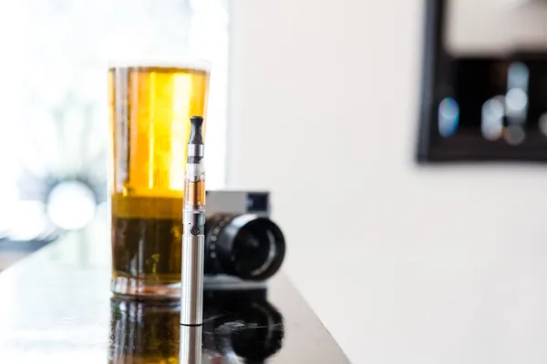 E-cigarette with a pint of beer and camera — Stock Photo, Image
