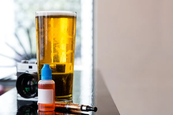 Glass of beer and gadgets on table — Stock Photo, Image