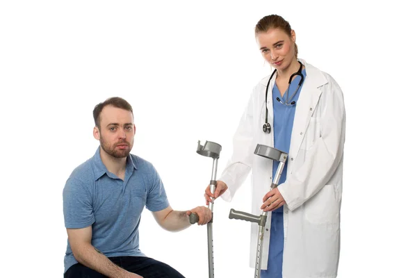 Kvinnelig lege som gir Crutches til pasienten – stockfoto