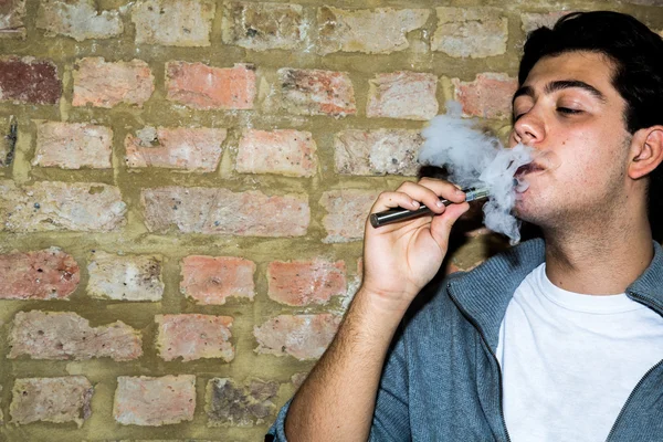 Young man enjoying a satisfying e-cigarette — Stock Photo, Image