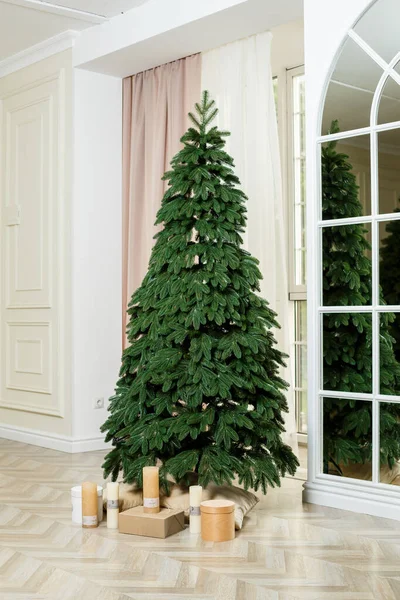 Een onversierde kerstboom met geschenken eronder. Goede nieuwjaarsgeest. — Stockfoto