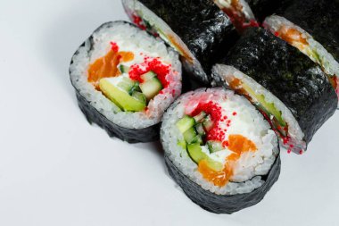 Avokado, taze balık ve beyaz tabakta kırmızı havyarlı Japon yemeği suşisi.