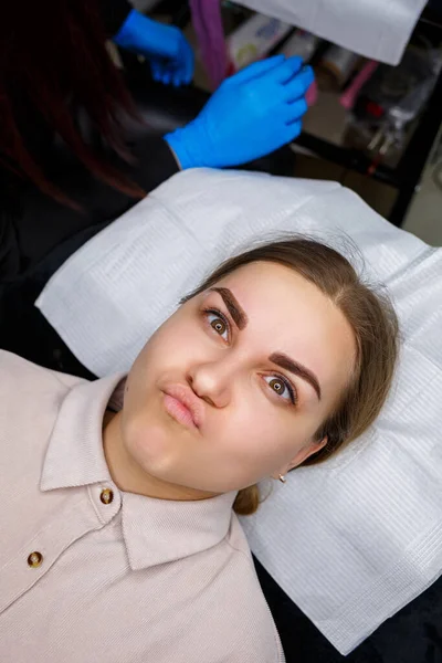 Kalıcı kaş dövmesi yaptıran genç bir kadının yakın plan fotoğrafı..